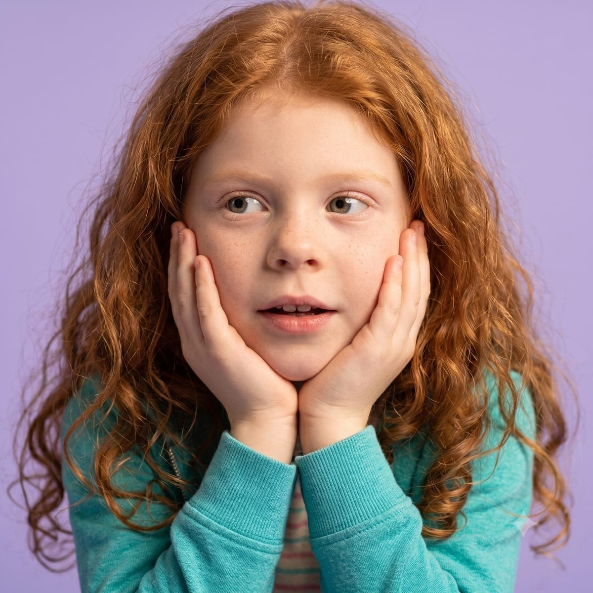 A thoughtful child resting her chin on her hands, deep in thought